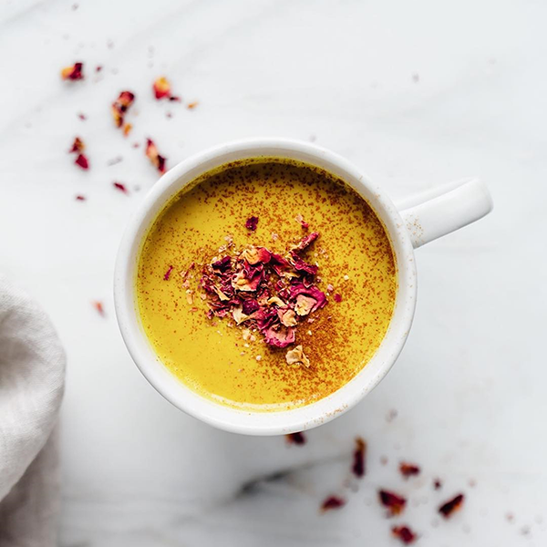 Spicy turmeric latte with cinnamon and rose toppings